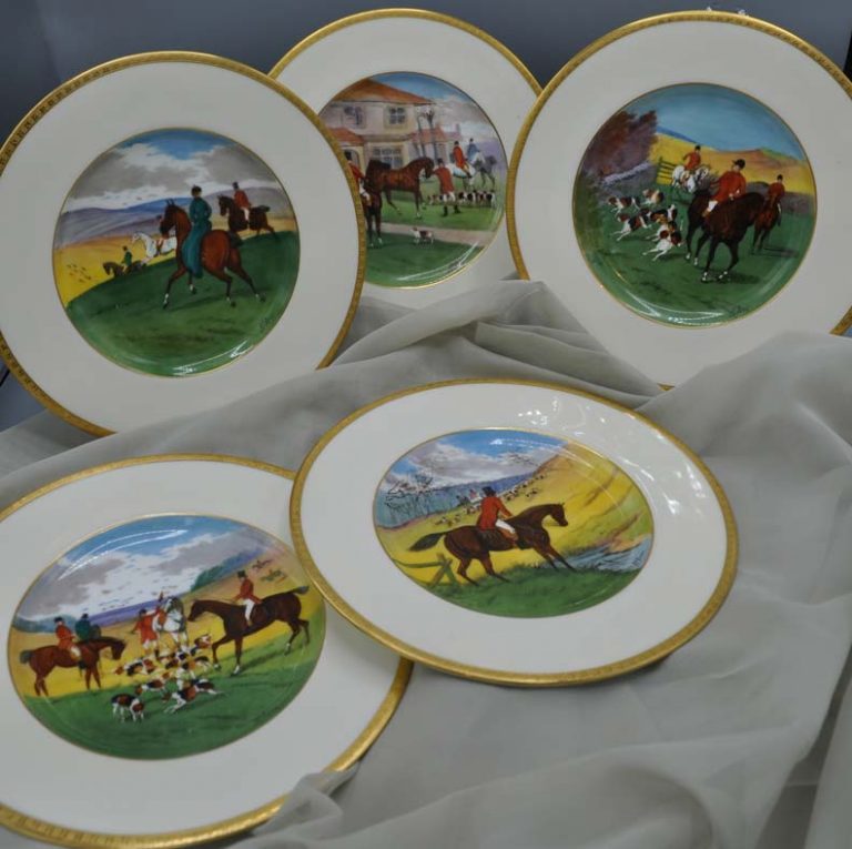 Painted china plate collection depicting a foxhunting scene with three riders and a pack of foxhounds
