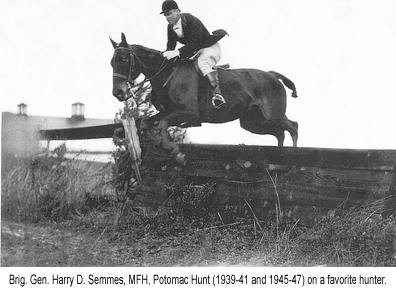 Brig. Gen. Harry D. Semmes, MFH Potomac Hunt (1939-1941) riding a horse and jumping a fence