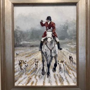 Huntsman blowing horn while cantering horse next to hounds